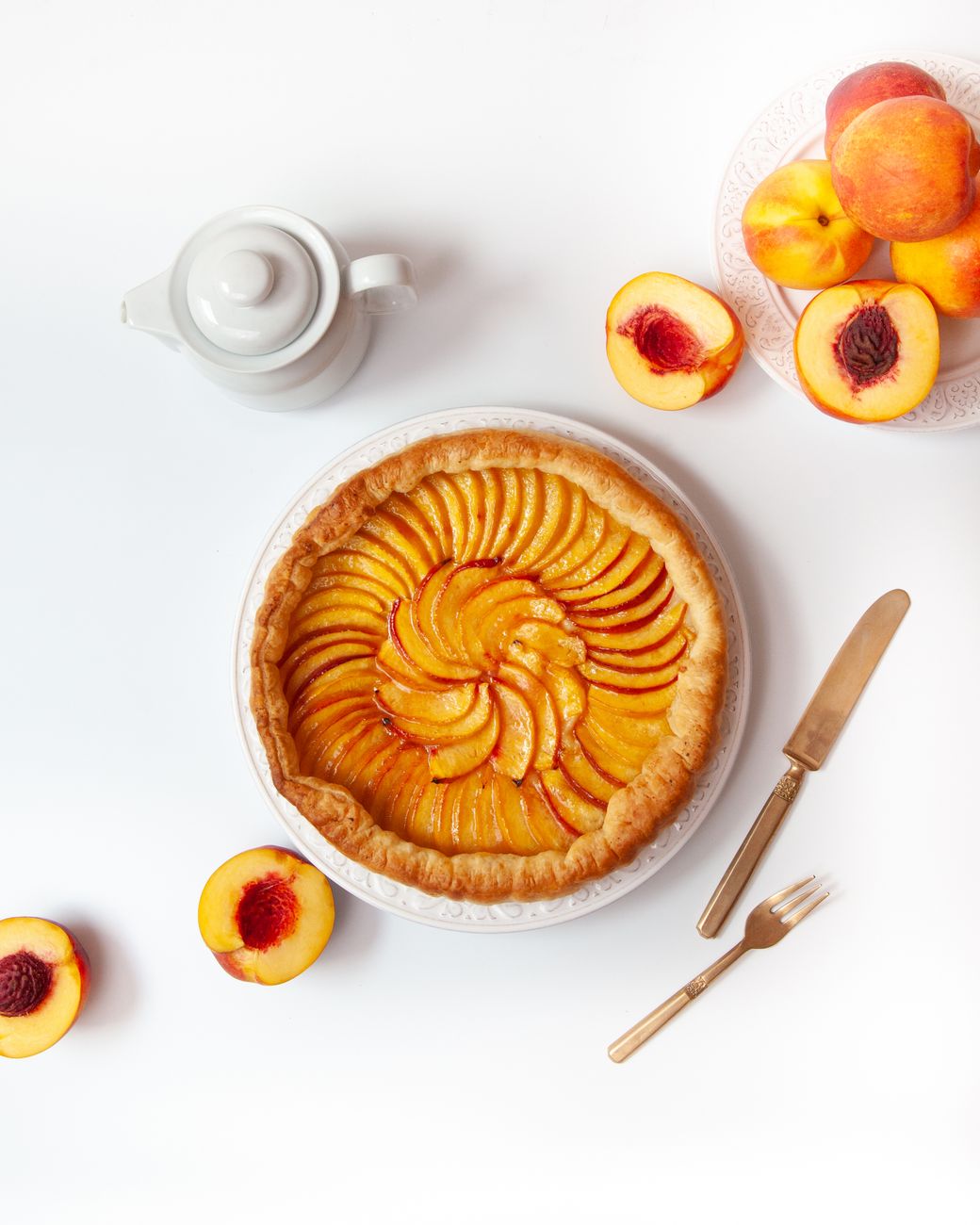 flat lay of peaches cake and teapot